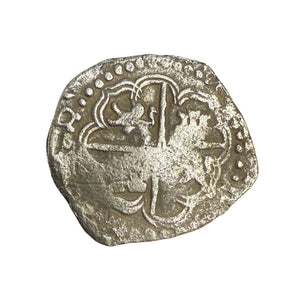Ancient silver coin with intricate designs on a white background